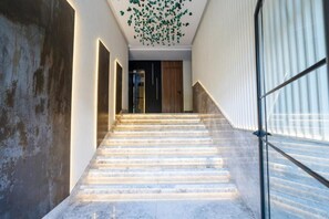 Una escalera de diseño moderno que conduce a una habitación con puerta de madera.
