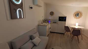A modern living room with a sofa, a coffee table, and a dining area with chairs and a table.