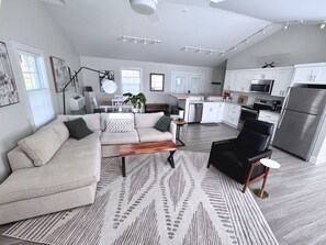Uma sala de estar moderna com sofá, mesa de centro e uma poltrona preta.