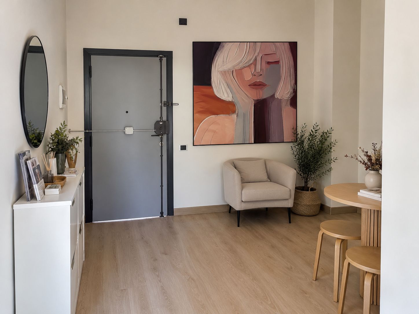 Una habitación moderna con puerta cerrada, un sofá, una mesa de comedor con sillas y un cuadro abstracto grande en la pared.