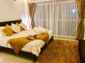 Ein Schlafzimmer mit einem Bett, Kissen, einer Decke und einem Teppich.