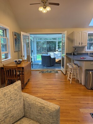 Una cocina con comedor, ventilador de techo y vista a un patio exterior.