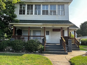 A two-story building with a porch, a welcome sign, and a mailbox. - CatalpaCorner 2-Bed Sit & Escape/Turnkey/Mid-term/Monthly/Weekly (Springfield)