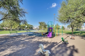 A playground with a slide, swings, and a turtle rideout. - Soothing 3-bedroom house with AC in charming Peoria (Peoria)