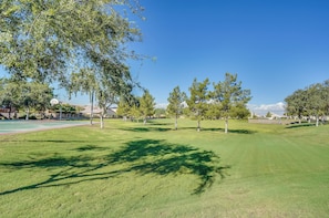 A well-maintained grassy area with trees and a basketball court. - Soothing 3-bedroom house with AC in charming Peoria (Peoria)