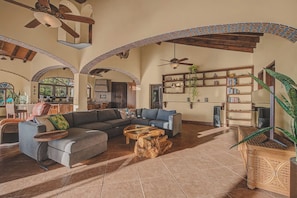 A spacious living area with a sectional sofa, a coffee table, and a bookshelf. - Villa Catalina: San Pancho 5BR Estate w/ Pool, Ocean Views, Sleeps 10 (San Francisco)
