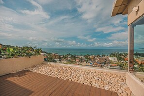 Ein Balkon mit Blick auf das Meer und eine Stadt.