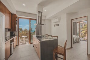 Eine moderne Küche mit Kochinsel, Holzschränken und Blick ins Freie.