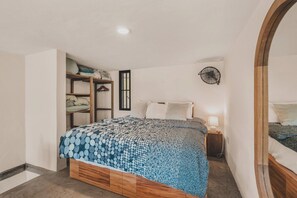A bedroom with a bed, bedside table, and a wardrobe. - Campanilla at Ipomea: Sayulita Loft w/ Terrace, Lap Pool, Jungle (Sayulita)