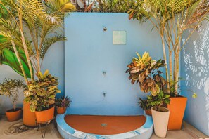 A blue wall with a water feature and potted plants. - Morro Cima Penthouse: Central Sayulita 2BR w/ Terrace, Pool & Ocean Views (Sayulita)