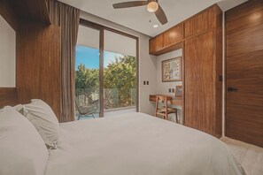 Ein Schlafzimmer mit einem großen Bett, einem Schreibtisch und Blick ins Freie.