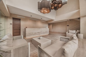 Um hall amplo com balcão de recepção, área de estar e escada.