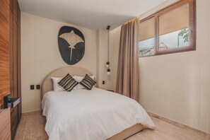 A bedroom with a bed, a wall-mounted artwork, a window with curtains, and a wooden floor. - Palmera Tropical at Caivama: Sayulita 2BR, Terrace & Plunge Pool (Sayulita)