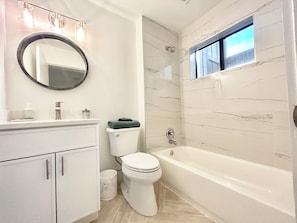 Ein Badezimmer mit Toilette, Waschbecken und Badewanne.