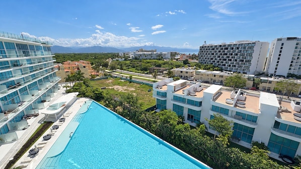 Un hôtel doté d’une piscine sur le toit, de plusieurs étages et offrant une vue sur le paysage urbain environnant.