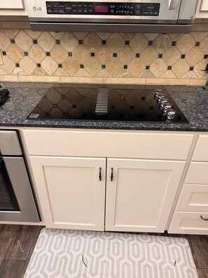 A kitchen with a built-in stove, a microwave, and a digital clock displaying the time. - 3-2.5 house in gated Westlake Hills w/pool, heated spa, fenced yard & EV charger (Austin)