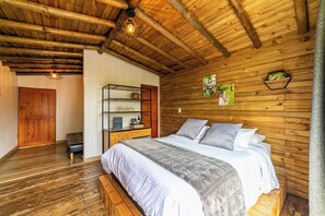 Une pièce en bois avec un lit, une étagère contenant divers objets et une porte.