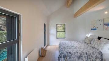 Un dormitorio con cama, ventana y vista al exterior.