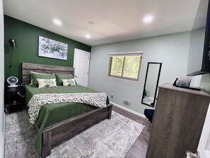 A bedroom with a bed, bedside table, lamp, window, and a dresser. - Whole Black Hawk Home w/ Game Room and Home Gym Near Casinos and Hiking! (Black Hawk)
