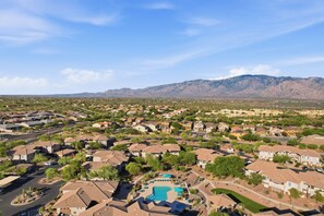 A residential area with houses, a swimming pool, and mountains in the background. - Oro Valley 2BR Condo with Pool-View Balcony, Shared Pool & Hot Tub (Oro Valley)