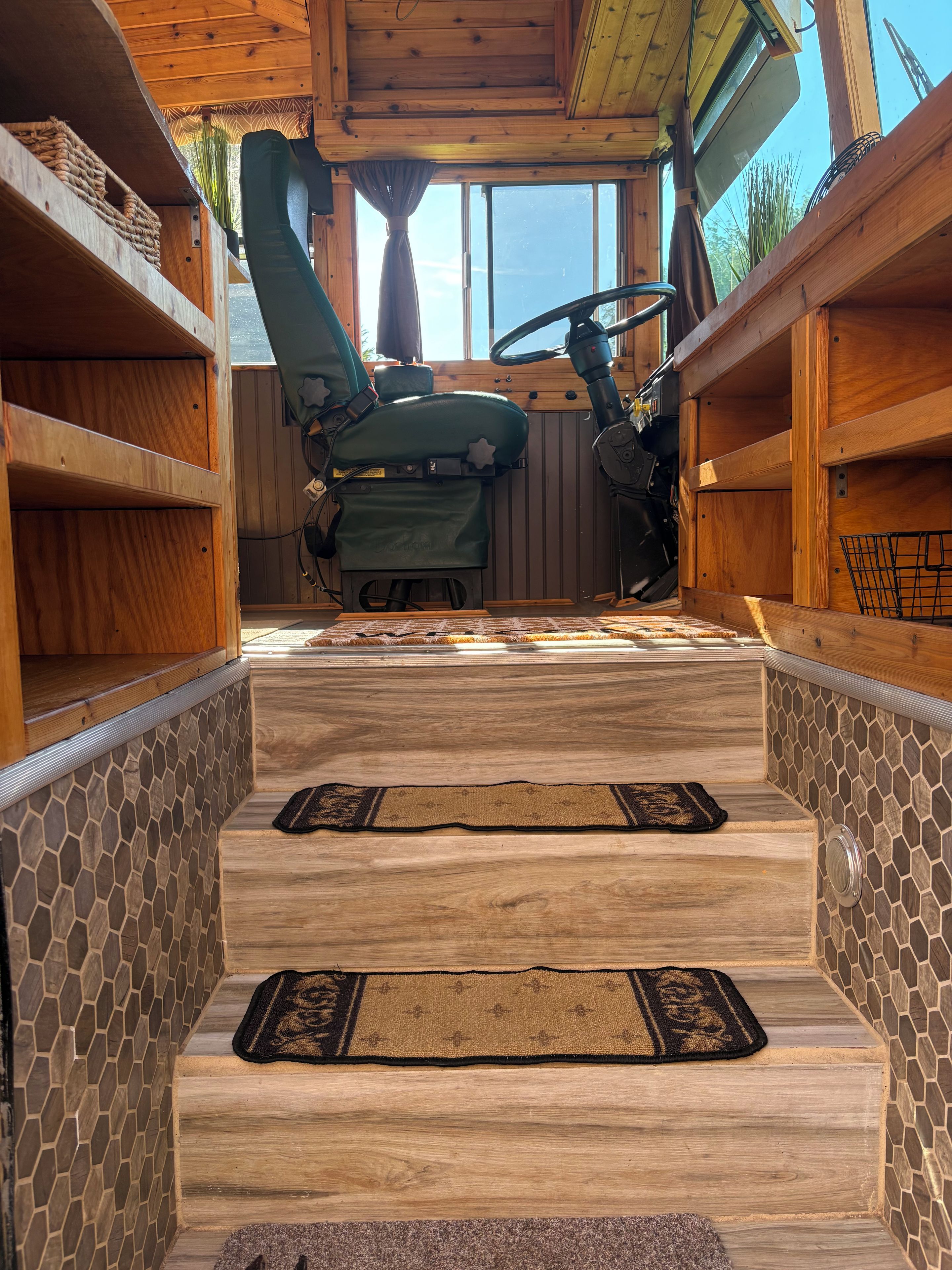Ein Holzinterieur mit einer Wand aus Steinplatten, einem grünen Stuhl und einer hölzernen Bank.