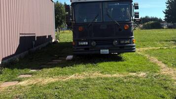 A bus parked in a grassy area with a building in the background.