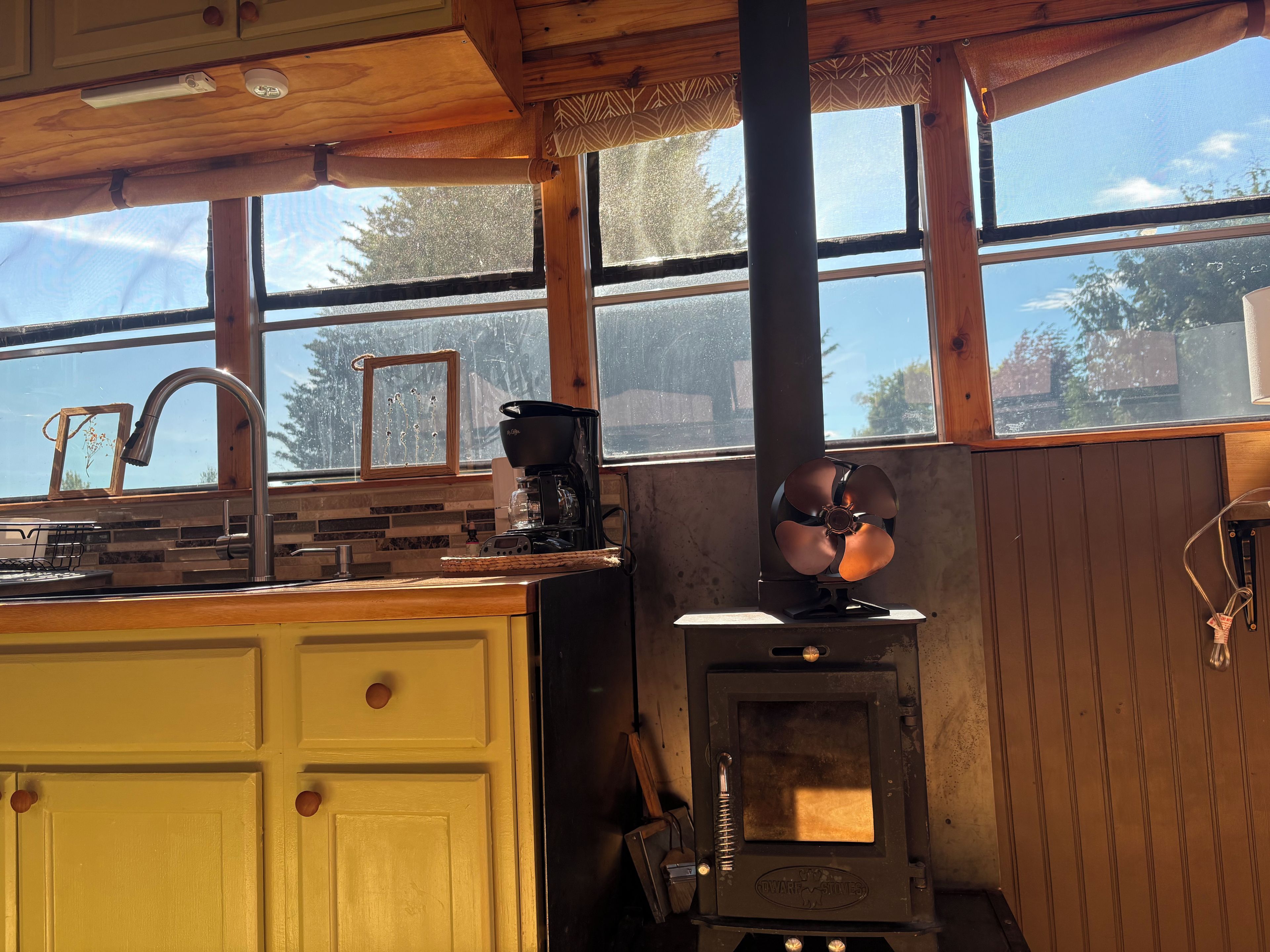 A kitchen with a wooden countertop, a coffee maker, and a wood stove.