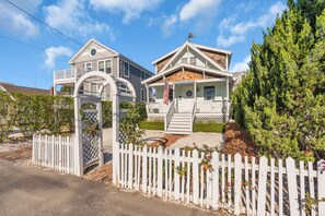 A two-story house with a covered porch and a white picket fence. - Shells & Whistle Beach Cottage
Short Walk to SeaWatch Beach Manasquan (Manasquan)