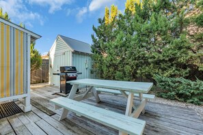 A wooden deck with picnic tables, a barbecue grill, and a shed. - Shells & Whistle Beach Cottage
Short Walk to SeaWatch Beach Manasquan (Manasquan)