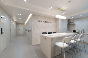 Een moderne hotelentree met een receptiebalie, een bar en een bord waarop Seoul, Jongno staat.