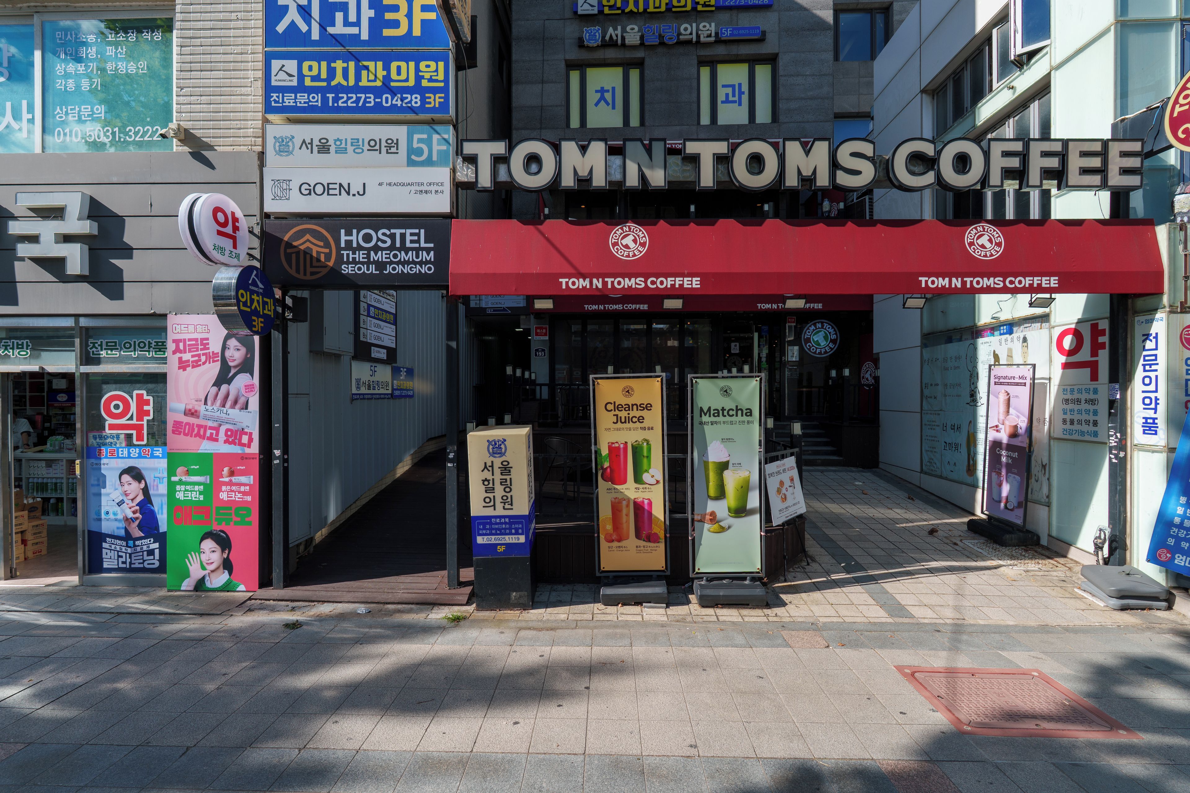 A storefront with a red awning and signage for Tom N Tom's Coffee.