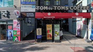 A storefront with a red awning and signage for Tom N Tom's Coffee.