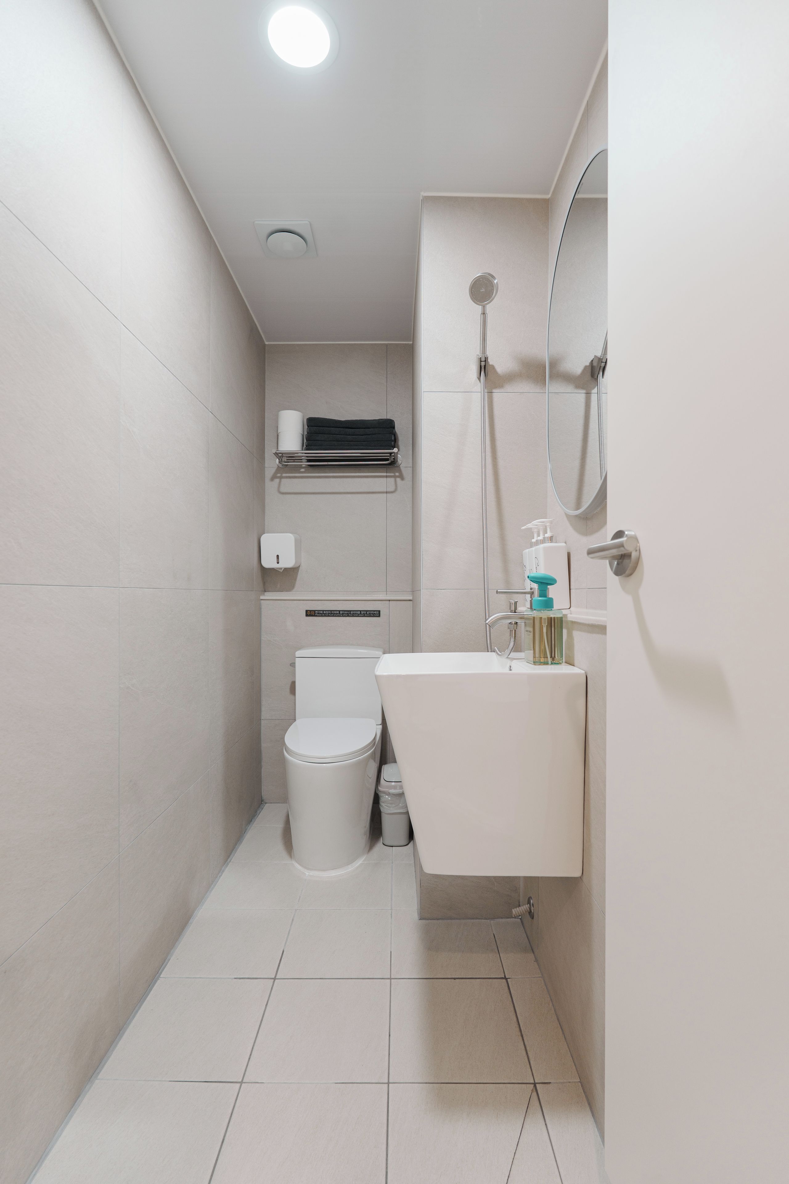 A compact bathroom with a toilet, sink, and shower.