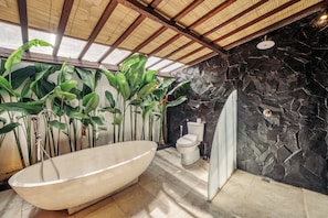 Un bagno con una vasca da bagno indipendente, un water e un box doccia.