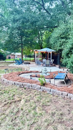 A patio area with outdoor seating, a pergola, and a small water feature.
