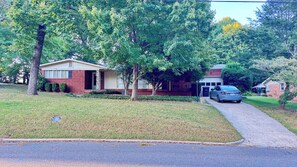 A residential house with a driveway, a garage, and a car parked in the driveway.