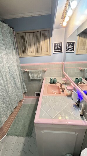 A bathroom with a pink sink, a towel rack, and a shower curtain. - Family-Friendly 3BR with Private B-Ball Court & Patio (Statesville)