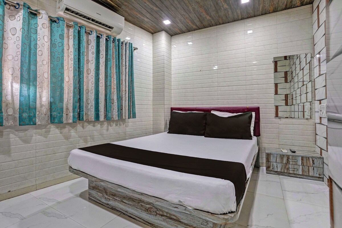 Un dormitorio con cama, cortinas, un equipo de aire acondicionado y una pared con baldosas.