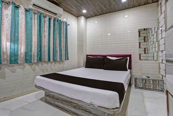 Un dormitorio con cama, cortinas, un equipo de aire acondicionado y una pared con baldosas.