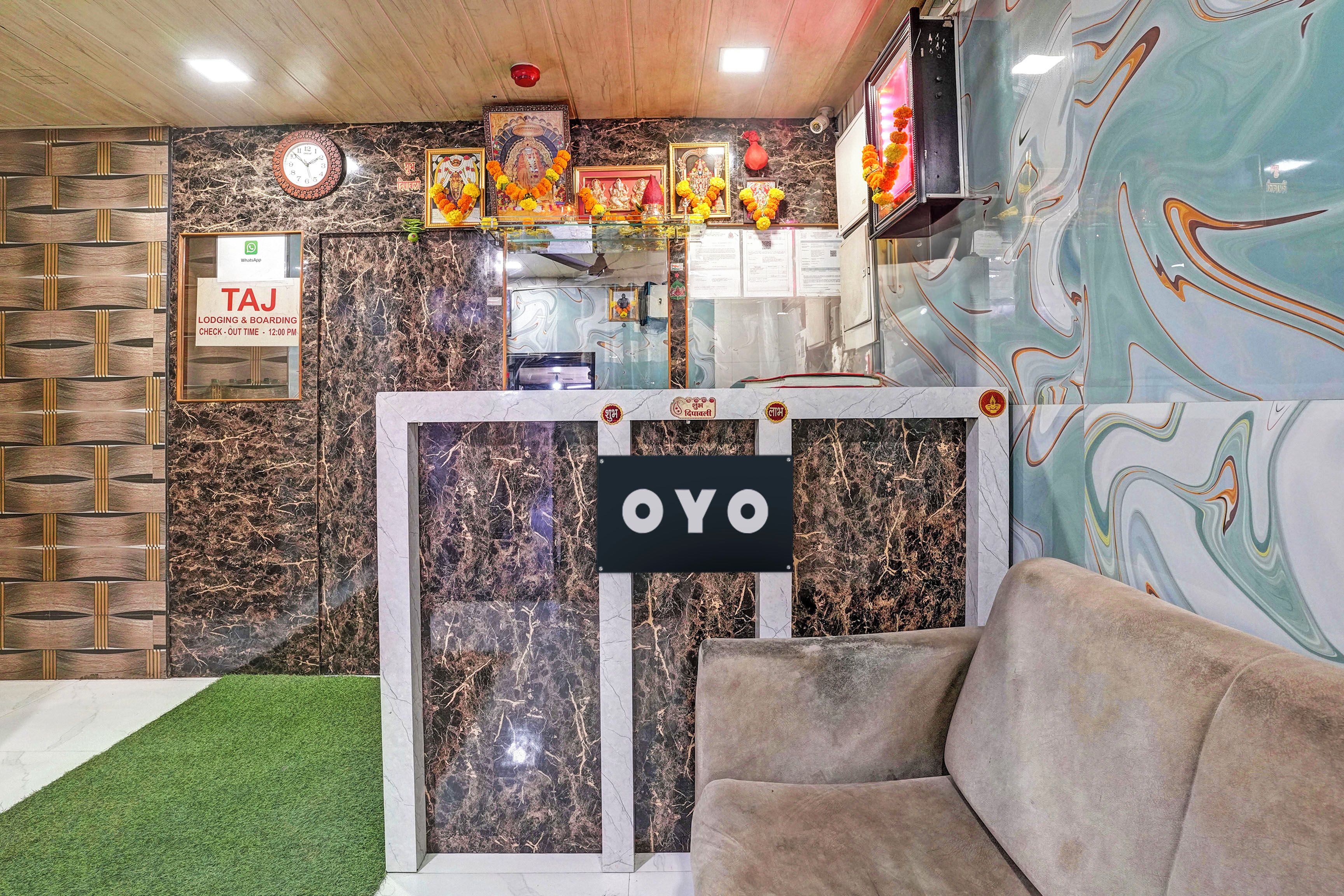A reception area with a check-out sign, a clock, and a sign with 'OYO' branding.
