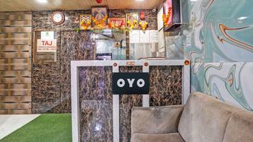 A reception area with a check-out sign, a clock, and a sign with 'OYO' branding.