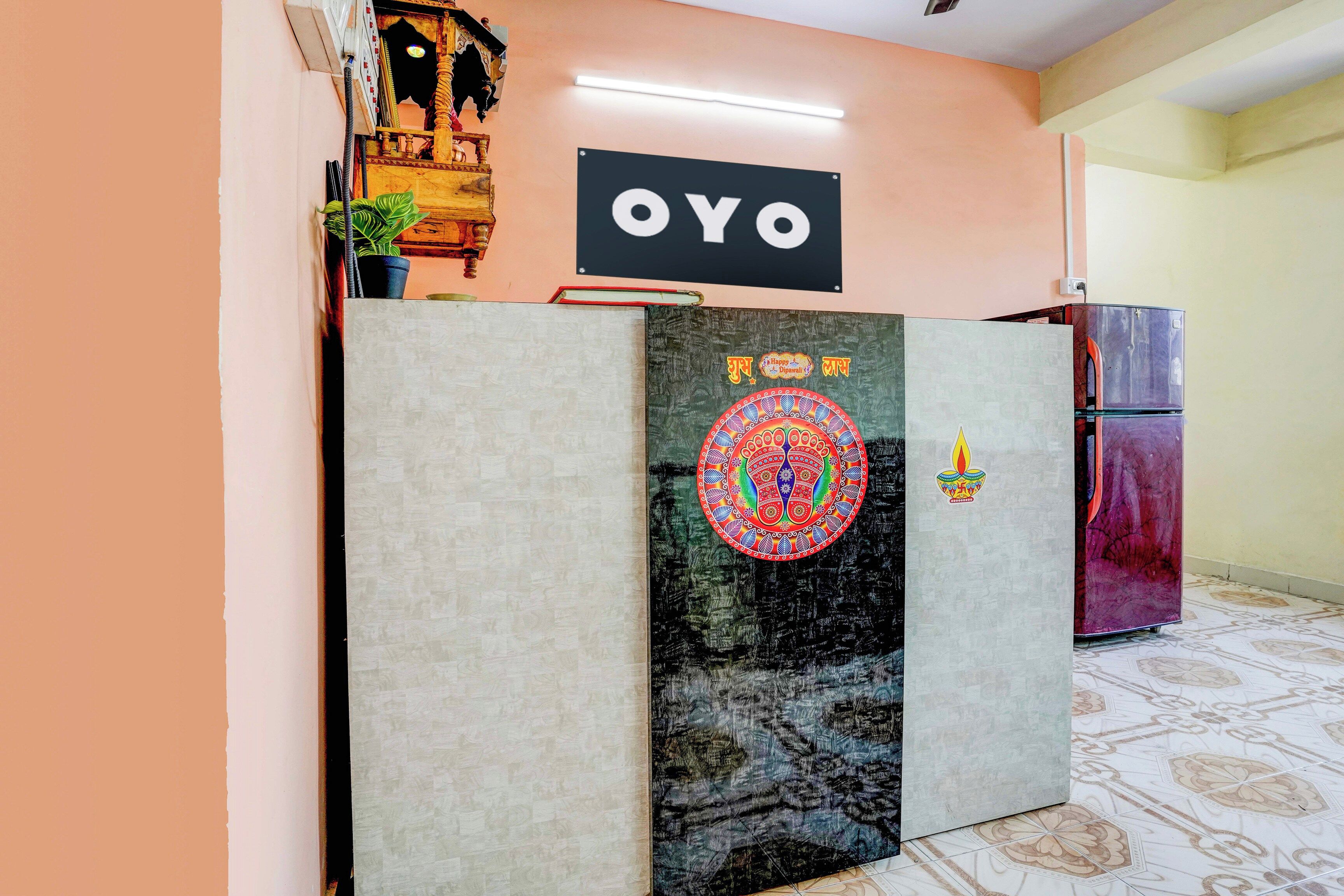 Una mesa de recepción con un cartel que dice 'OYO' y un adorno con el texto 'Feliz Diwali'.
