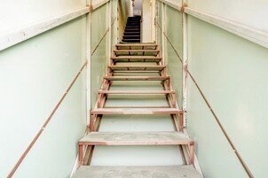 A staircase with metal railings and wooden steps leading to a door at the top.