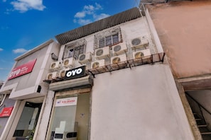 Un hotel con varias unidades de aire acondicionado, una entrada visible y un cartel que dice 'Hotel Blue Sea'.