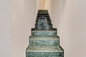 Una escalera con acabado de mármol que sube a un piso superior.