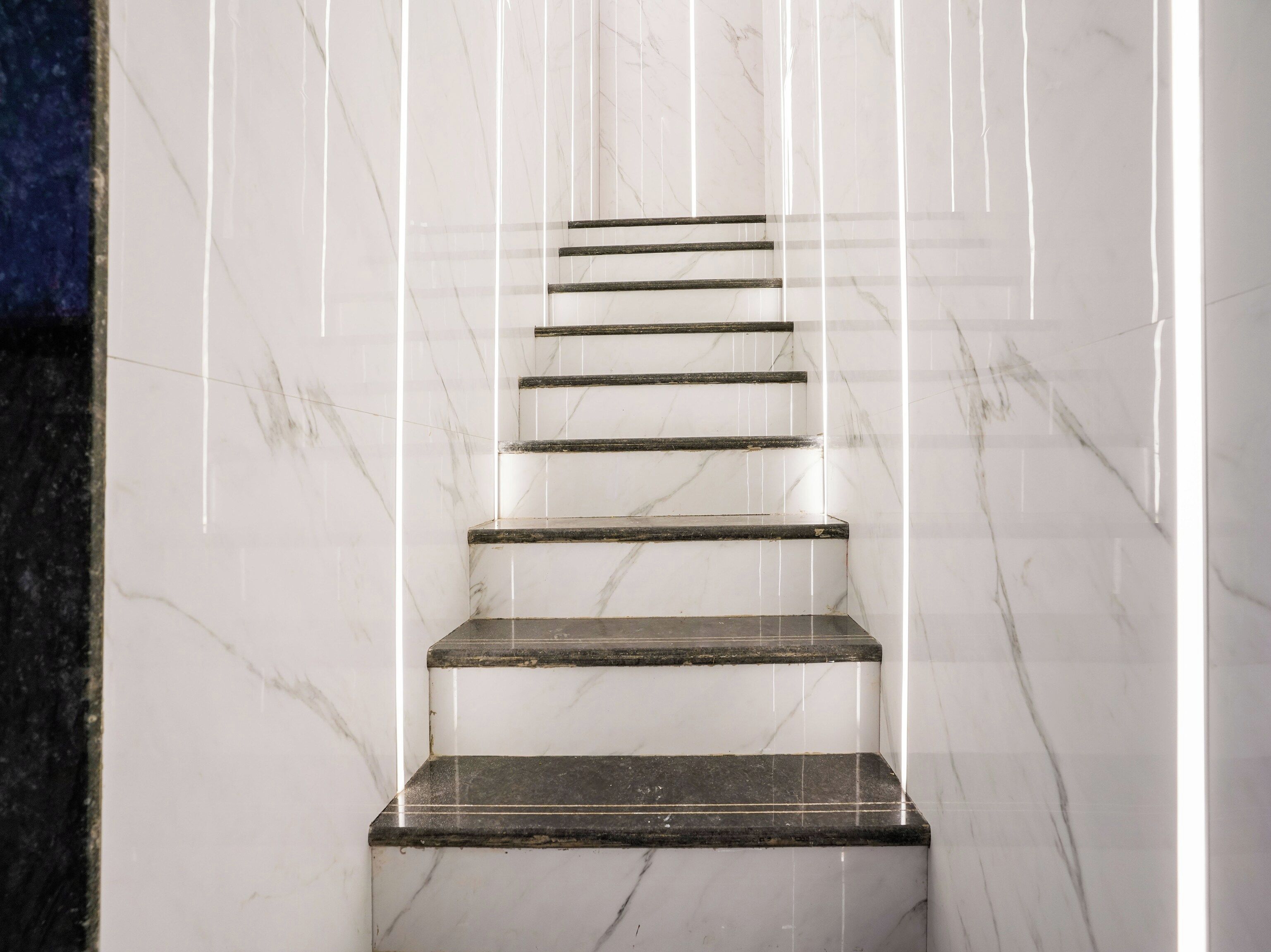 Un conjunto de escaleras de mármol con barandilla de vidrio.