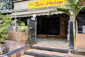 A hotel entrance with a sign reading 'Hotel Guruv Heritage.'