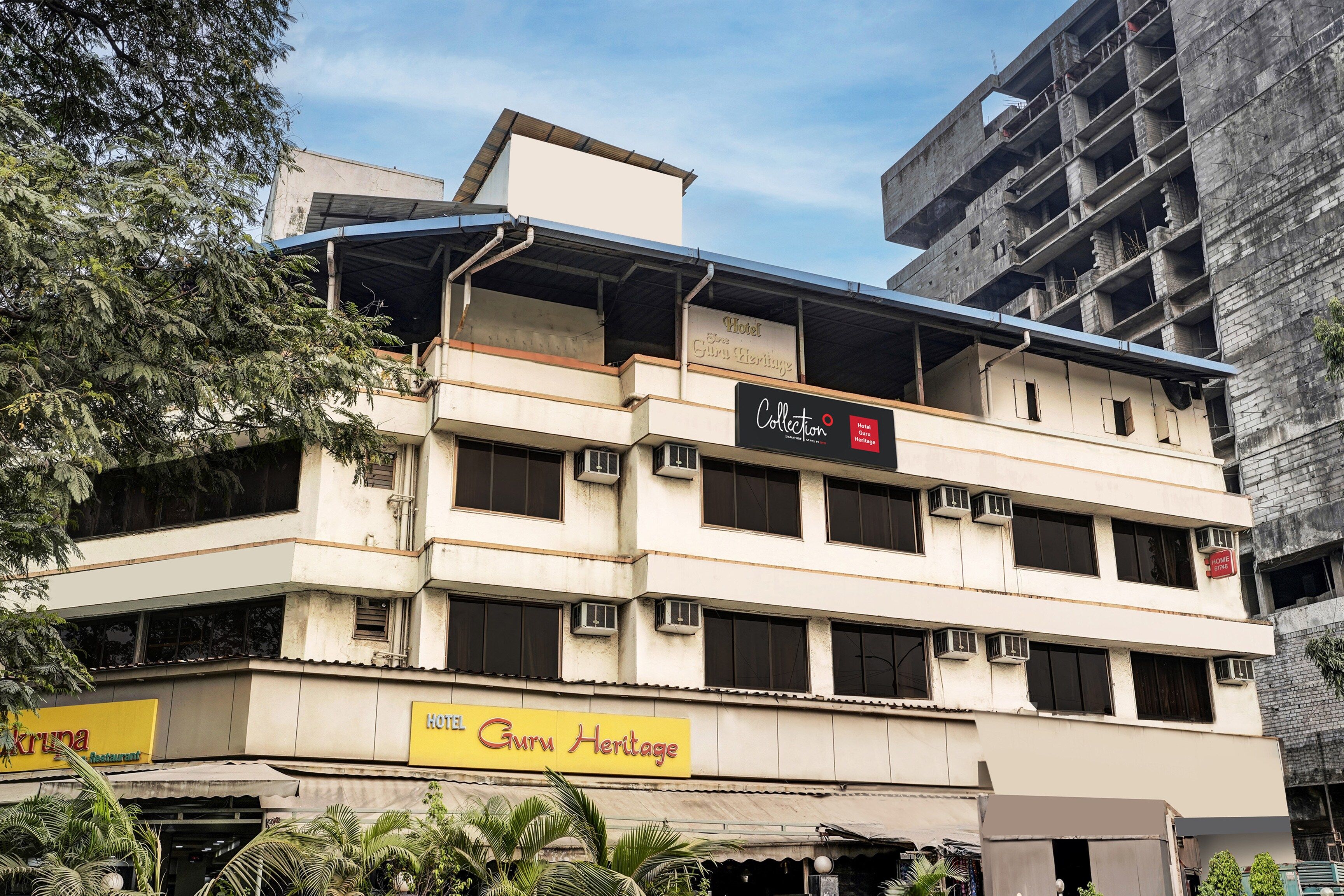 A multi-story building with a sign for 'Hotel Guru Heritage' and a restaurant named 'Kruna.'
