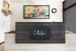 A reception desk with a framed artwork above it and a clock on the wall. - Collection O Guru Heritage Kalamboli (Panvel)