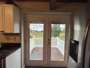 A kitchen with a double door leading to a wooden deck. - Private Modern Lodge 2-bedroom apartment in peaceful Saint Leonard (Saint Leonard)